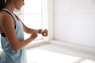 Woman checking fitness tracker in gym, closeup. Space for text Photo of Woman checking fitness tracker in gym, closeup. Space for text