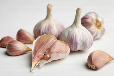 Fresh organic garlic on white wooden table, closeup Photo of Fresh organic garlic on white wooden table, closeup