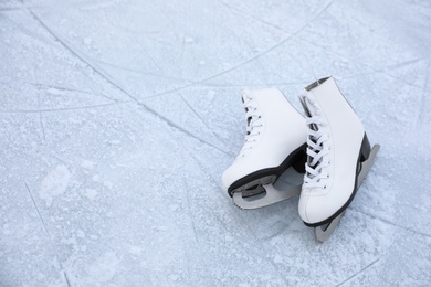 Figure skates with laces on ice, space for text. Winter outdoor activities Photo of Figure skates with laces on ice, space for text. Winter outdoor activities