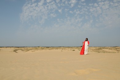 Jesus Christ walking with stick in desert. Space for text Photo of Jesus Christ walking with stick in desert. Space for text