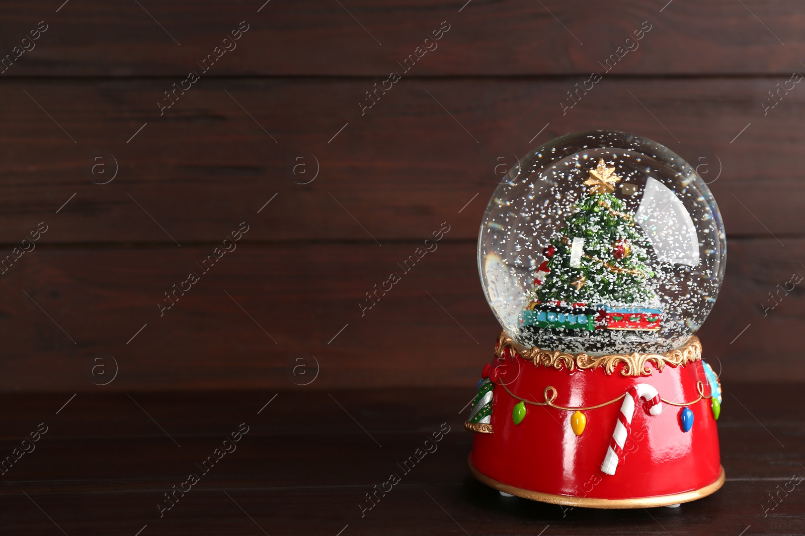 Beautiful snow globe with Christmas tree on wooden table, space for text Photo of Beautiful snow globe with Christmas tree on wooden table, space for text