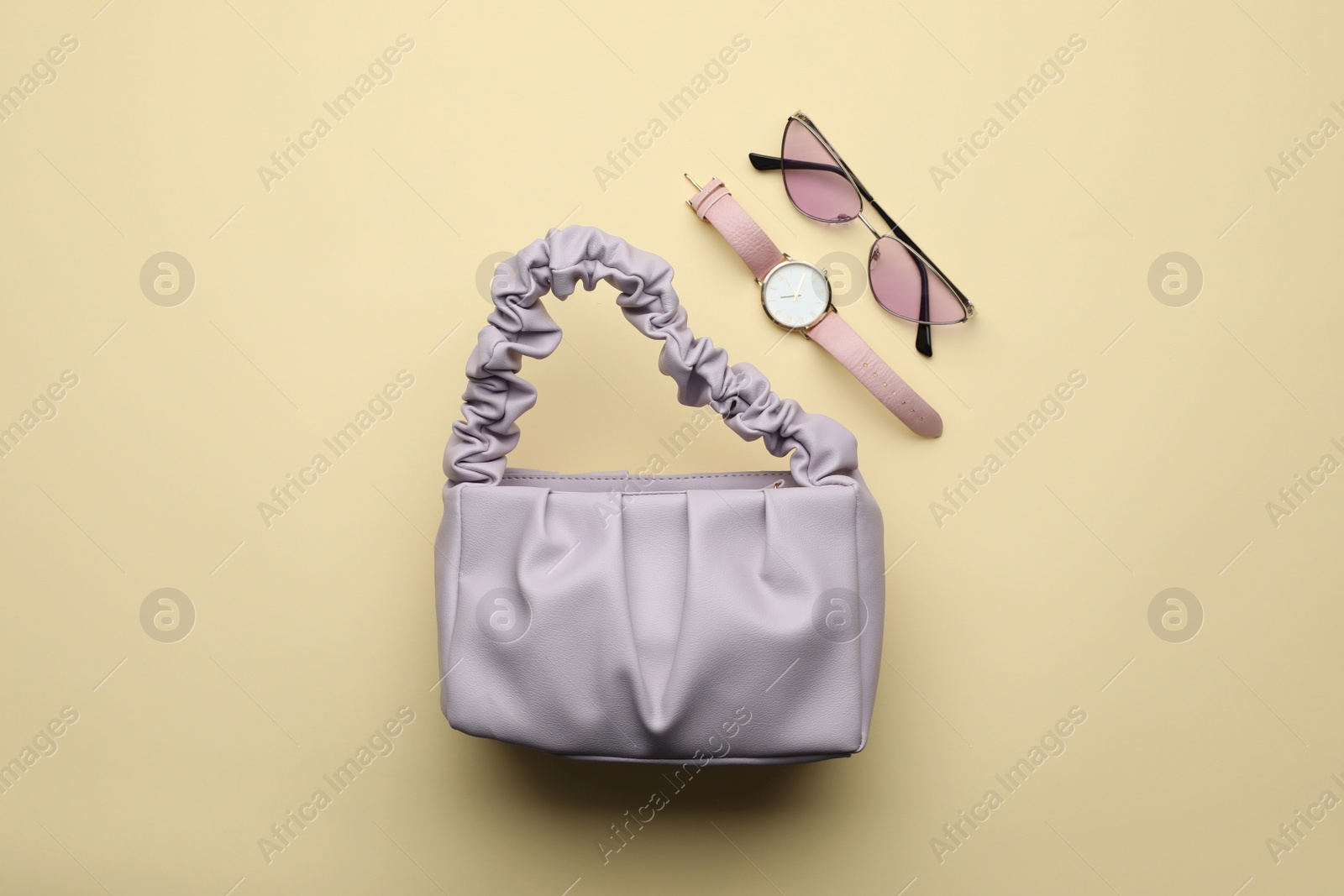 Stylish woman's bag, watch and sunglasses on beige background, flat lay Photo of Stylish woman's bag, watch and sunglasses on beige background, flat lay