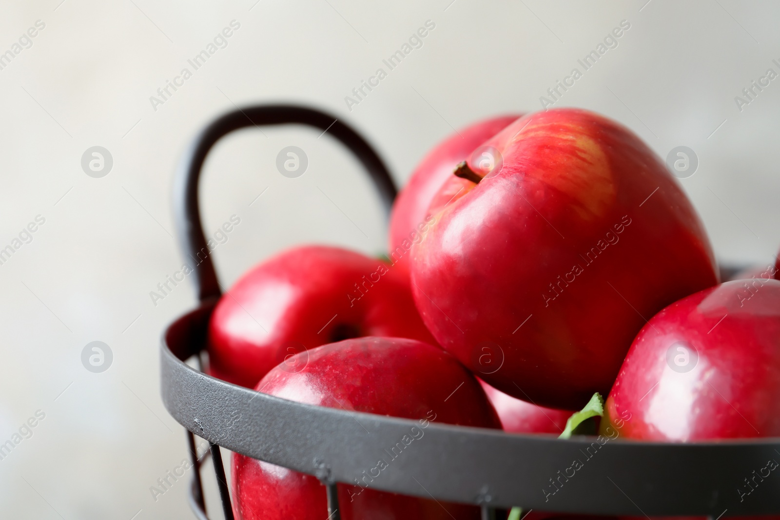 Basket with fresh ripe red apples on light background, closeup Photo of Basket with fresh ripe red apples on light background, closeup