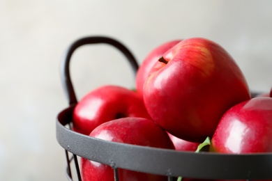 Basket with fresh ripe red apples on light background, closeup Photo of Basket with fresh ripe red apples on light background, closeup