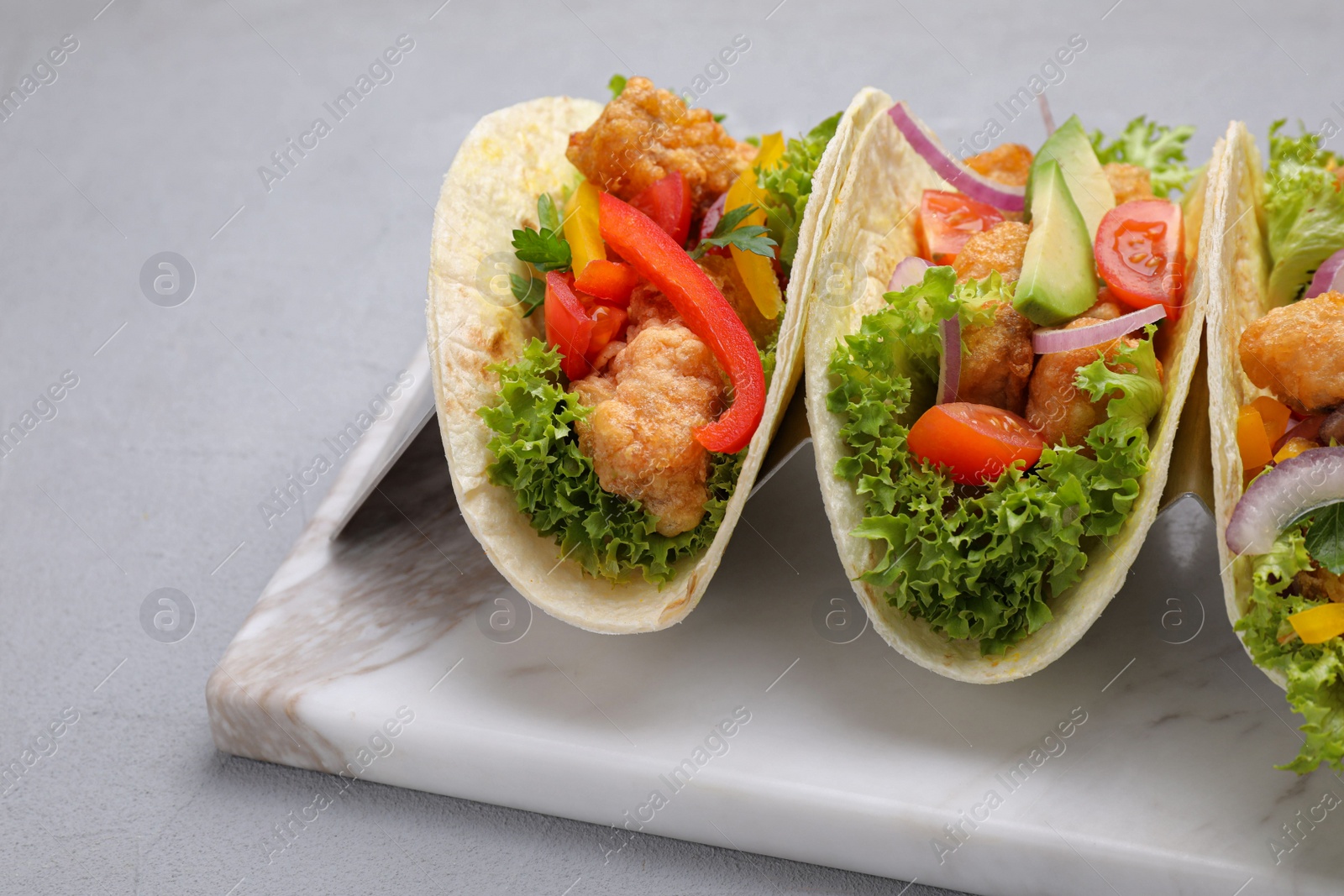 Delicious fish tacos served on grey table, closeup Photo of Delicious fish tacos served on grey table, closeup