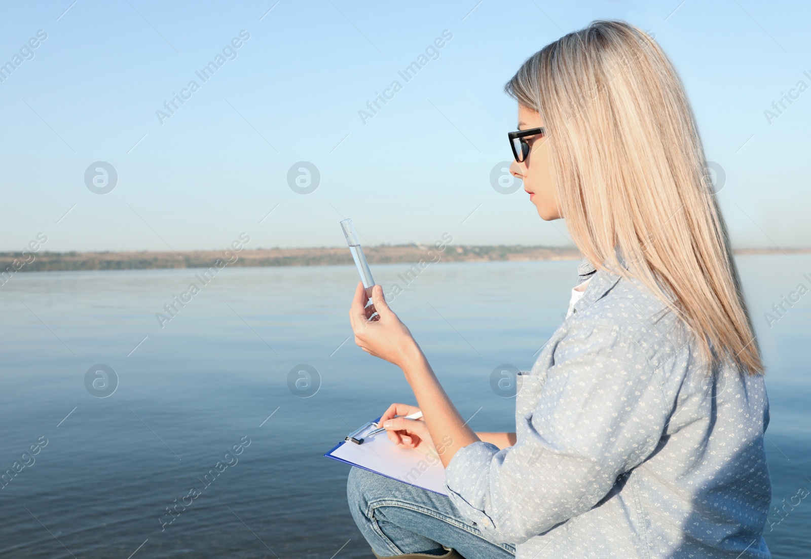 Scientist with clipboard and sample taken from river Photo of Scientist with clipboard and sample taken from river
