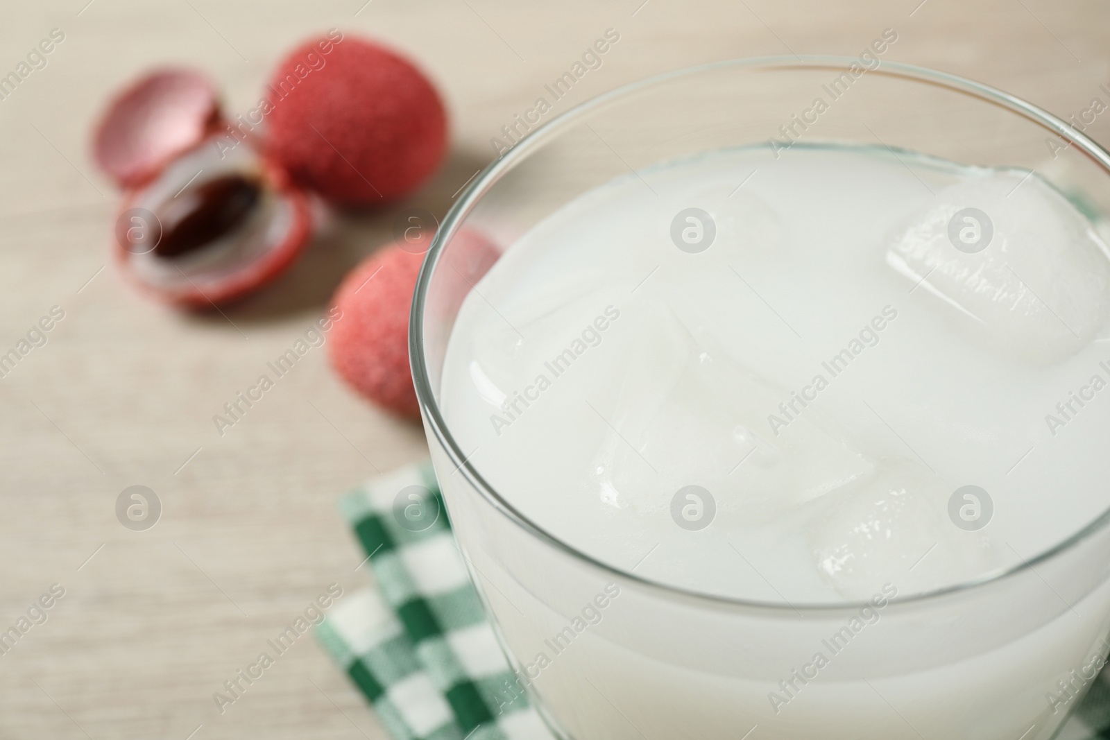 Glass with fresh lychee juice on table, closeup Photo of Glass with fresh lychee juice on table, closeup