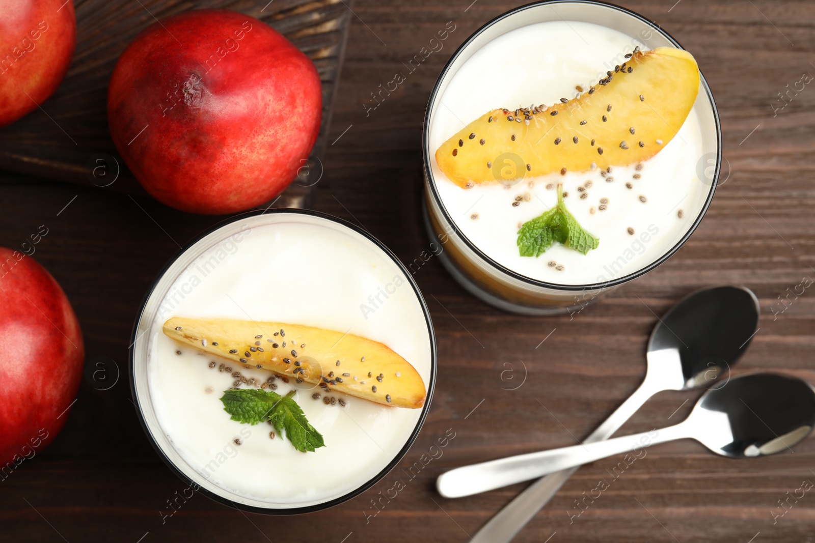 Tasty peach dessert with yogurt and chia seeds served on wooden table, flat lay Photo of Tasty peach dessert with yogurt and chia seeds served on wooden table, flat lay