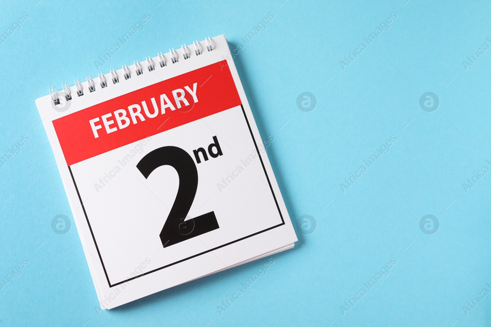Top view of calendar with date February 2nd on light blue background, space for text. Groundhog day Photo of Top view of calendar with date February 2nd on light blue background, space for text. Groundhog day