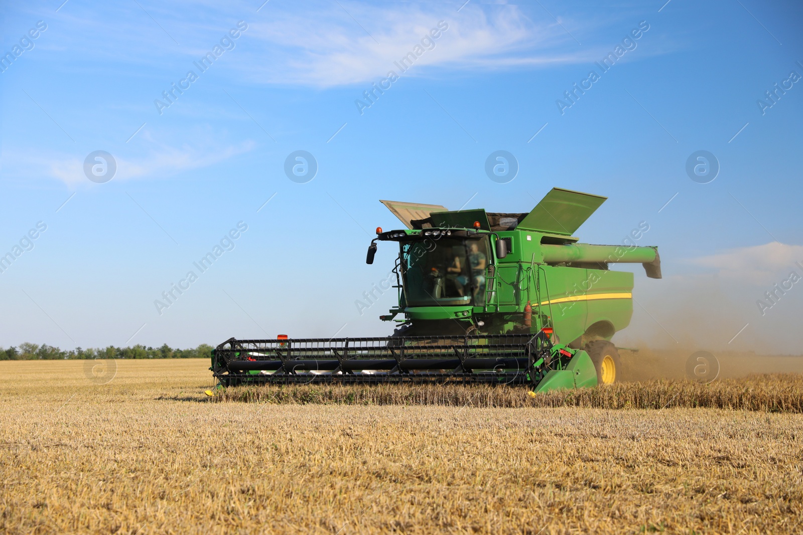 Modern combine harvester working in agricultural field Photo of Modern combine harvester working in agricultural field