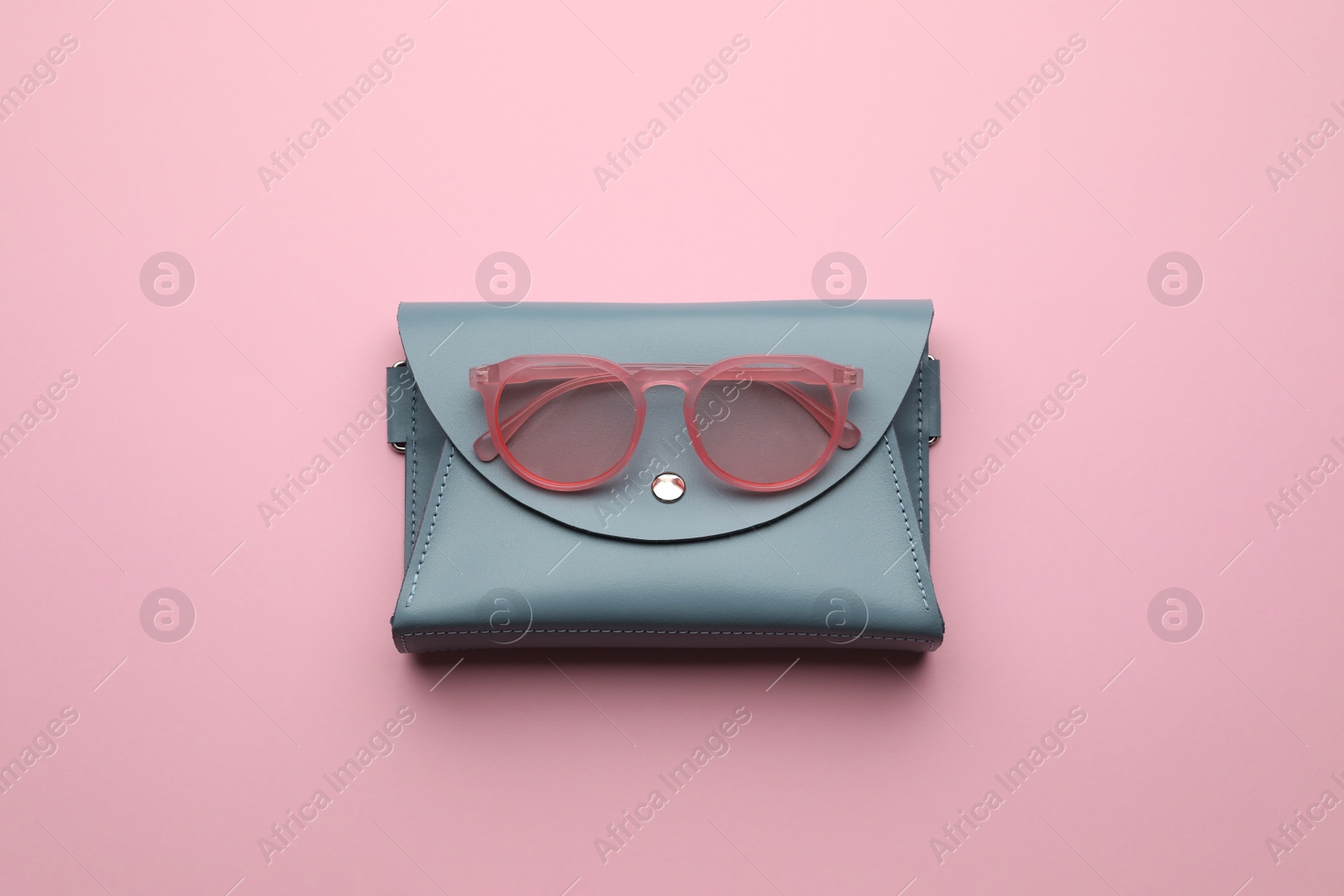 Stylish woman's bag and sunglasses on pink background, top view Photo of Stylish woman's bag and sunglasses on pink background, top view