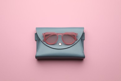 Stylish woman's bag and sunglasses on pink background, top view Photo of Stylish woman's bag and sunglasses on pink background, top view