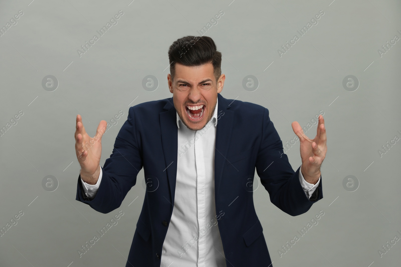 Angry man on grey background. Hate concept Photo of Angry man on grey background. Hate concept