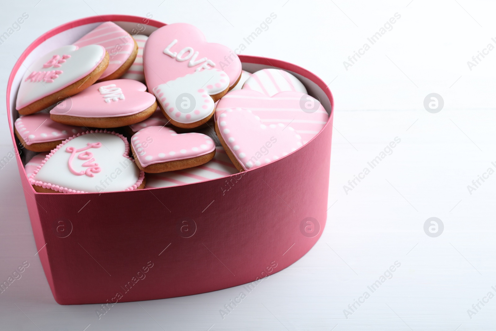 Delicious heart shaped cookies in box on white table. Valentine's Day Photo of Delicious heart shaped cookies in box on white table. Valentine's Day