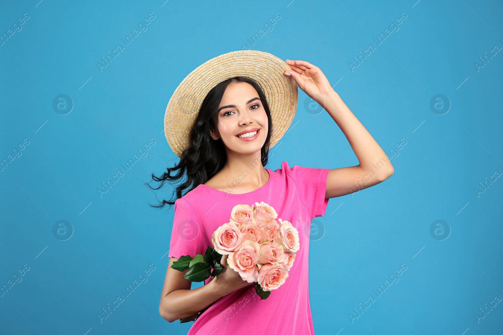 Portrait of smiling woman with beautiful bouquet on light blue background Photo of Portrait of smiling woman with beautiful bouquet on light blue background