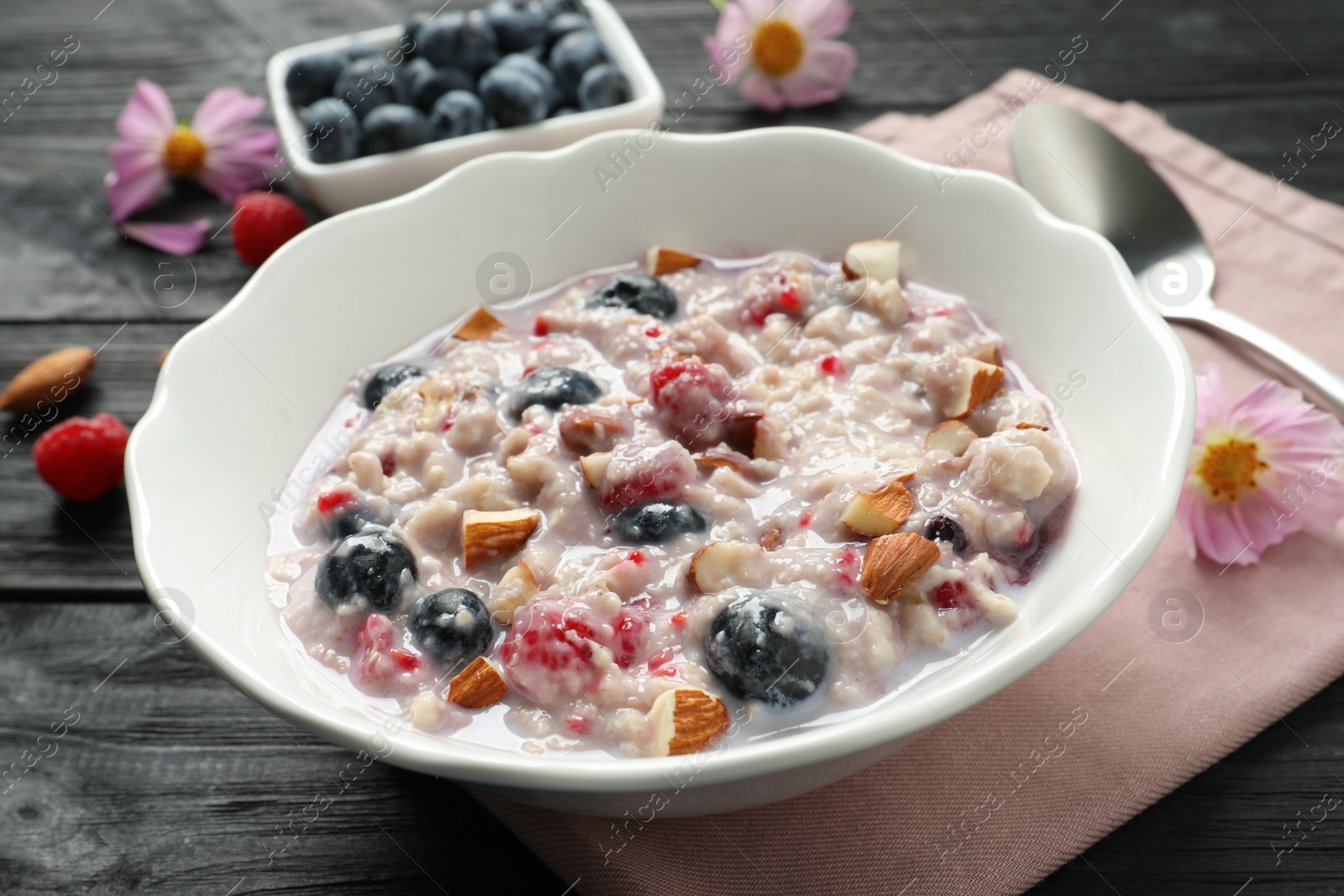 Tasty oatmeal porridge with toppings on black wooden table, closeup Photo of Tasty oatmeal porridge with toppings on black wooden table, closeup