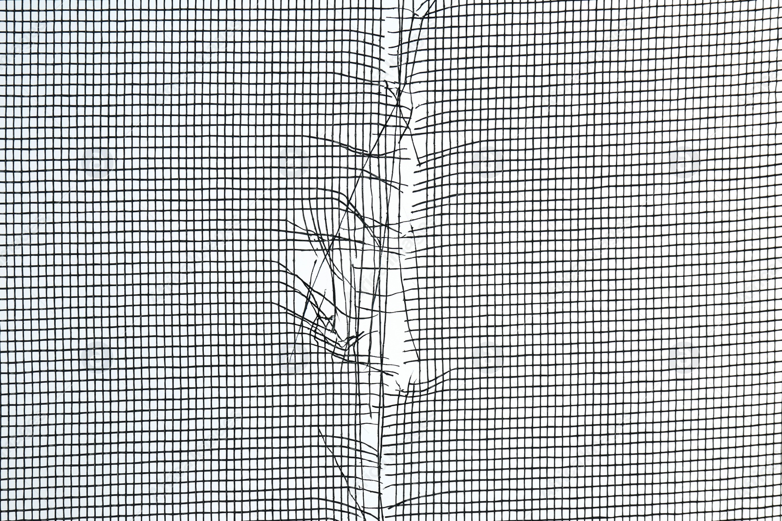 Photo of Torn window screen against white background, closeup