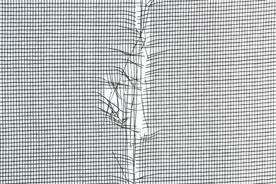 Torn window screen against white background, closeup Photo of Torn window screen against white background, closeup
