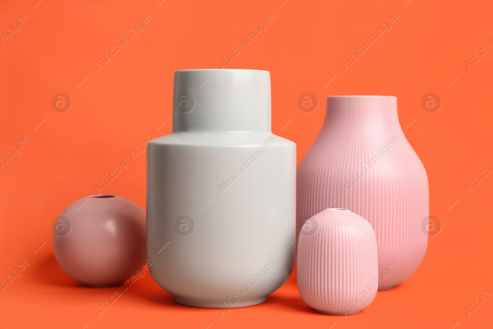 Stylish empty ceramic vases on orange background Photo of Stylish empty ceramic vases on orange background