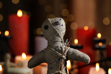 Voodoo doll with pins and dried flowers in dark room, closeup. Curse ceremony Photo of Voodoo doll with pins and dried flowers in dark room, closeup. Curse ceremony