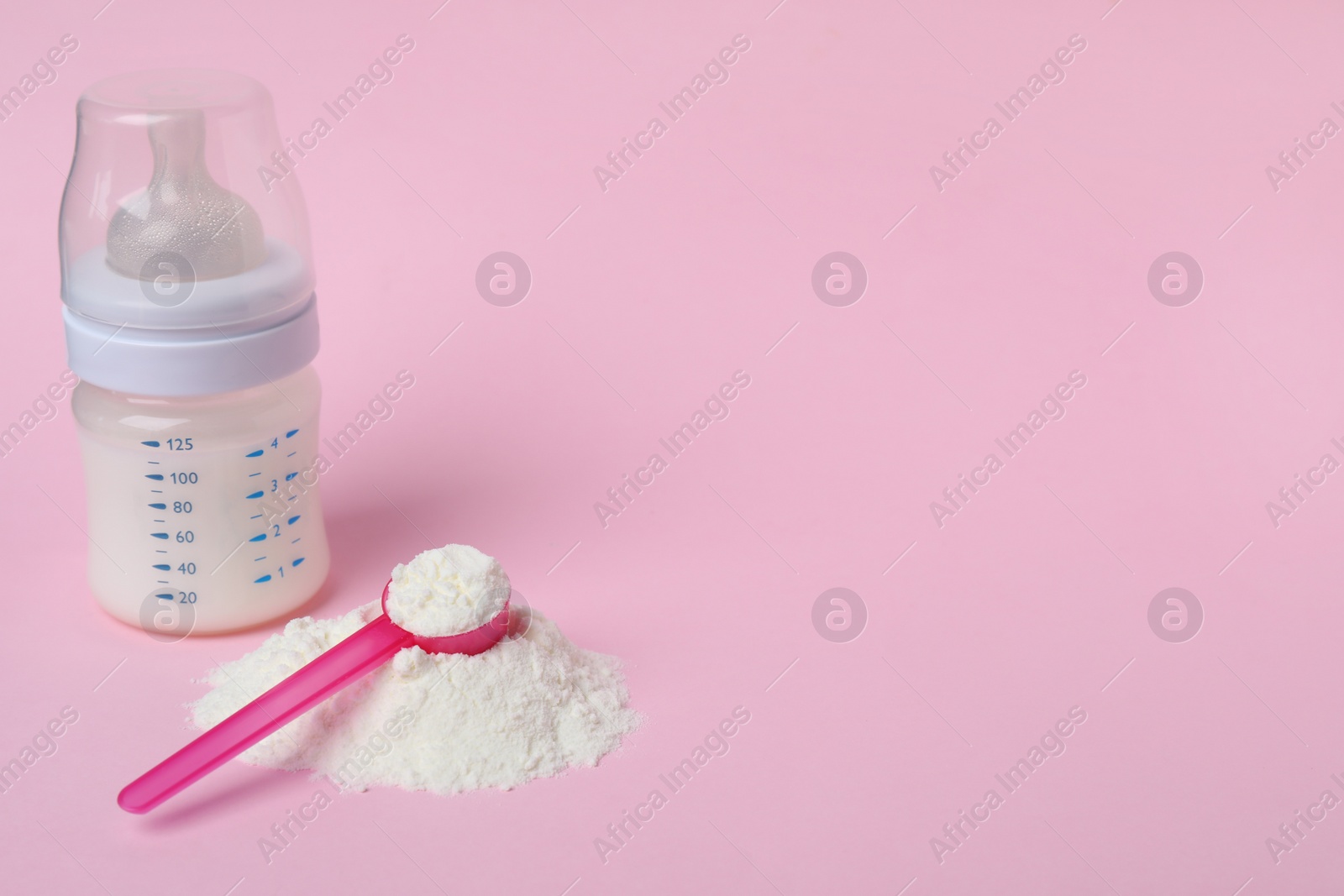 Powdered infant formula with scoop and feeding bottle on pink background, space for text. Baby milk Photo of Powdered infant formula with scoop and feeding bottle on pink background, space for text. Baby milk