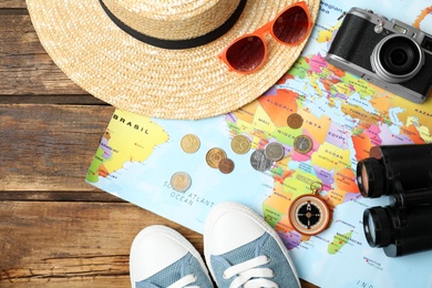 Flat lay composition with world map and different travel accessories on wooden table. Planning summer vacation trip Photo of Flat lay composition with world map and different travel accessories on wooden table. Planning summer vacation trip