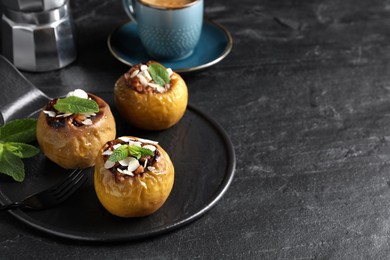 Delicious baked apples with nuts and mint served on black table, space for text Photo of Delicious baked apples with nuts and mint served on black table, space for text