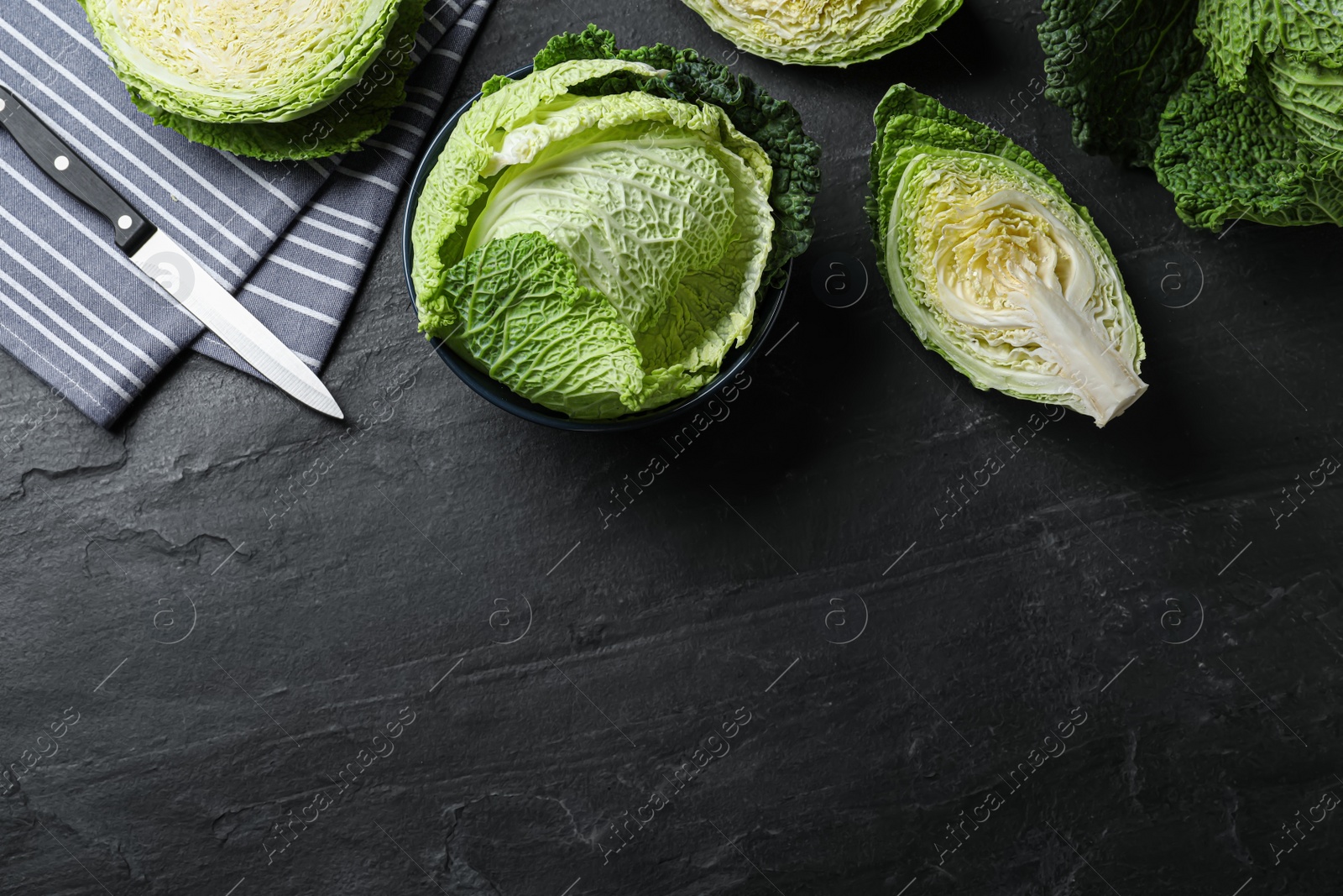 Cut fresh savoy cabbages on black table, flat lay. Space for text Photo of Cut fresh savoy cabbages on black table, flat lay. Space for text