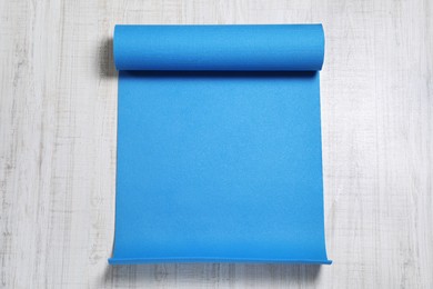 Bright camping mat on white wooden background, top view Photo of Bright camping mat on white wooden background, top view