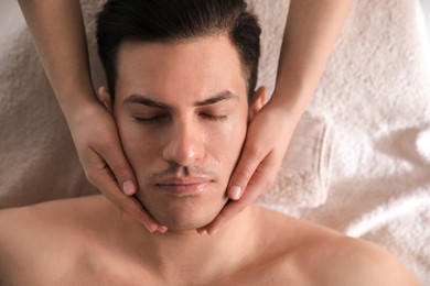 Man receiving facial massage in beauty salon, top view Photo of Man receiving facial massage in beauty salon, top view