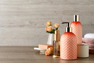 Stylish dispenser with liquid soap and other bathroom amenities on wooden table, space for text Photo of Stylish dispenser with liquid soap and other bathroom amenities on wooden table, space for text