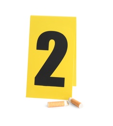 Photo of Cigarette stubs and crime scene marker with number two isolated on white