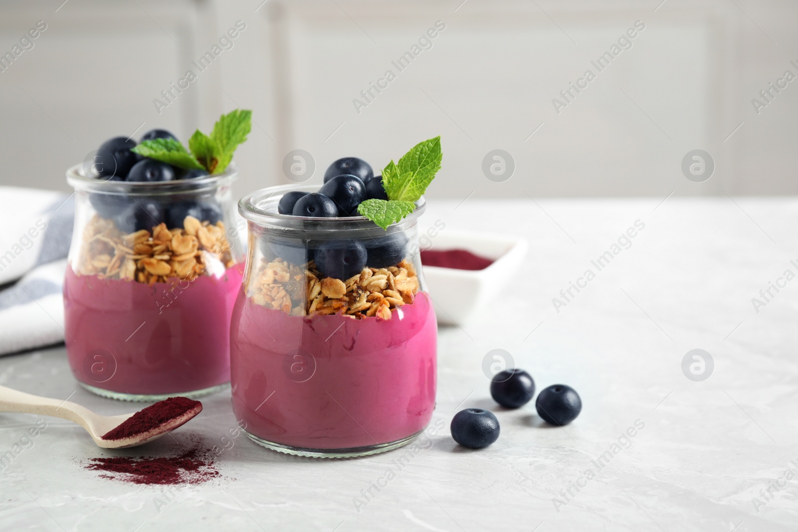 Tasty dessert with acai smoothie, granola and berries on marble table. Space for text Image of Tasty dessert with acai smoothie, granola and berries on marble table. Space for text