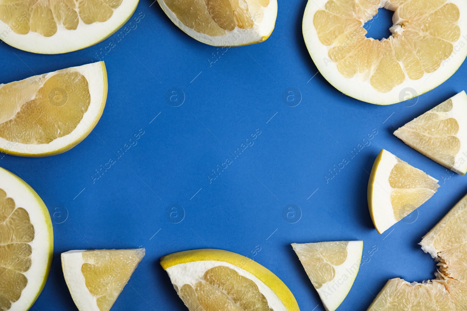 Frame made of delicious ripe pomelo slices on blue background, flat lay. Space for text Photo of Frame made of delicious ripe pomelo slices on blue background, flat lay. Space for text