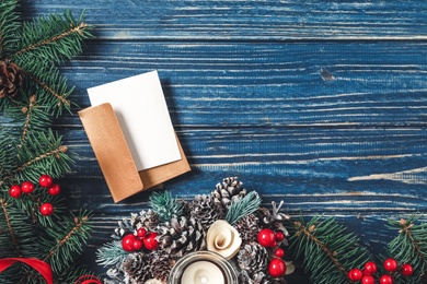 Photo of Flat lay composition with blank greeting card and Christmas decor on blue wooden table, space for text
