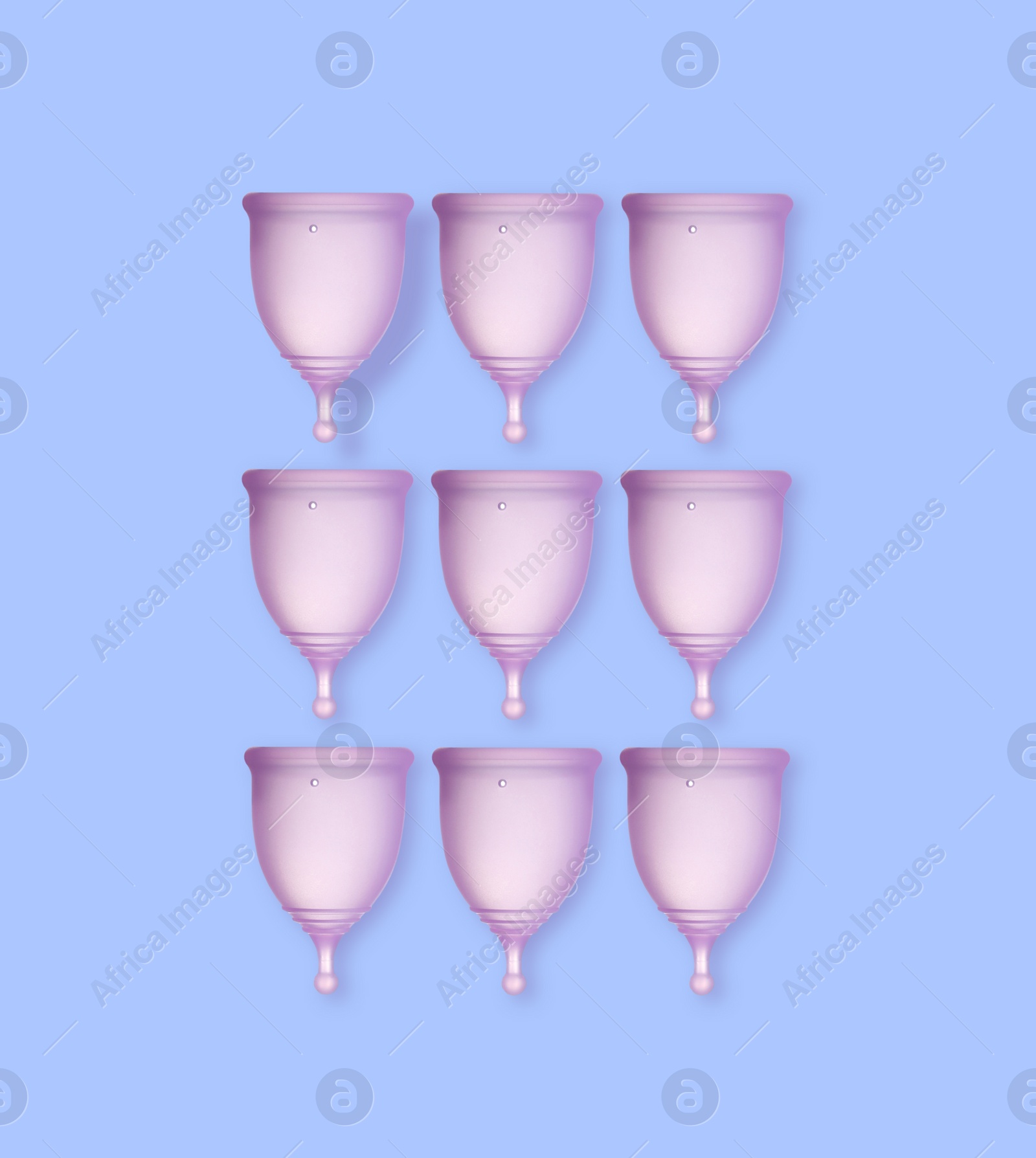 Many purple menstrual cups on light blue background, flat lay Image of Many purple menstrual cups on light blue background, flat lay