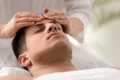 Photo of Man receiving facial massage in beauty salon