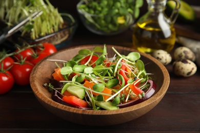 Salad with fresh organic microgreen in bowl on wooden table, closeup Photo of Salad with fresh organic microgreen in bowl on wooden table, closeup