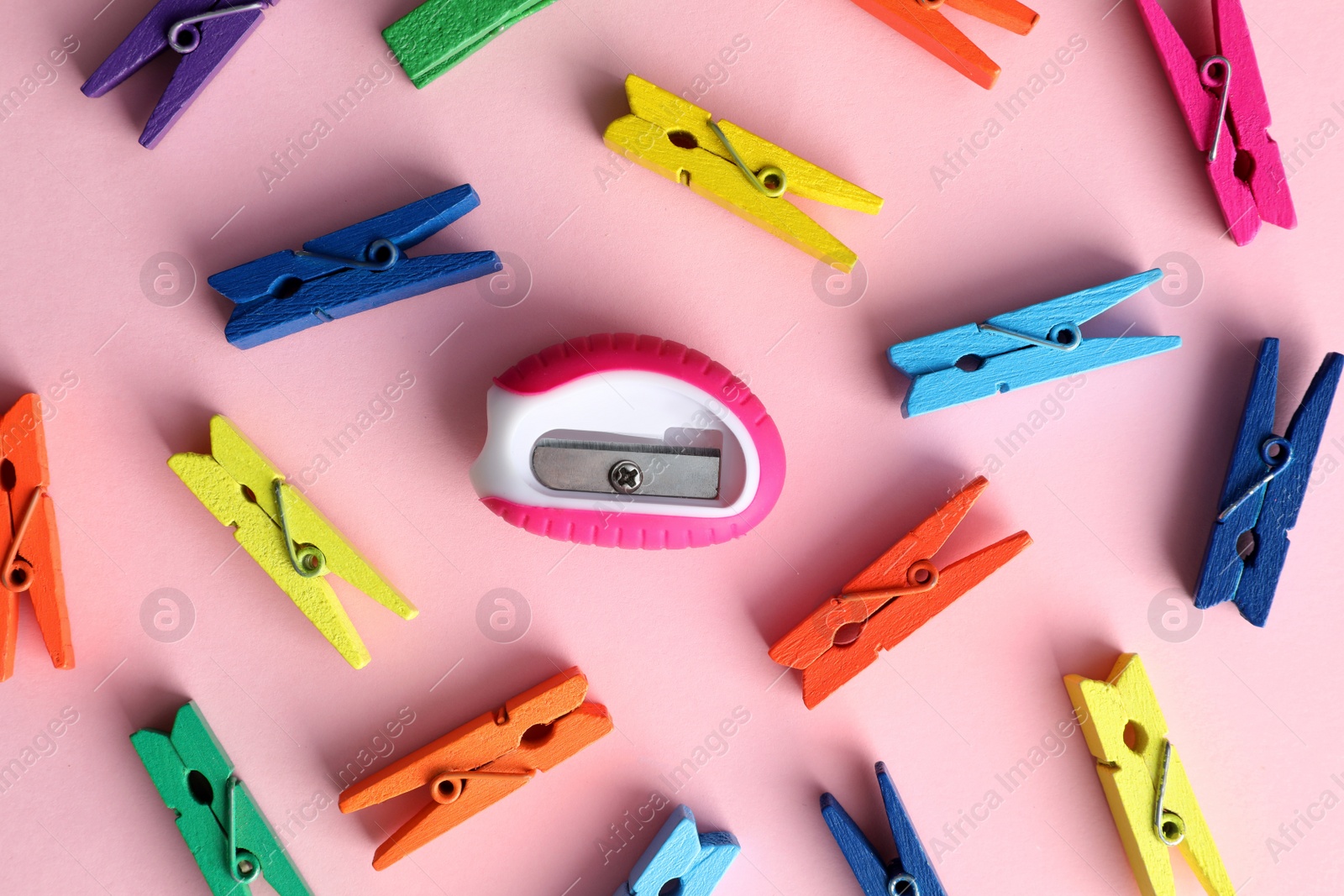 Colorful clothespins and sharpener on pink background, flat lay. Diversity concept Photo of Colorful clothespins and sharpener on pink background, flat lay. Diversity concept