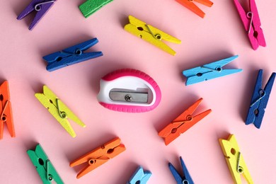 Colorful clothespins and sharpener on pink background, flat lay. Diversity concept Photo of Colorful clothespins and sharpener on pink background, flat lay. Diversity concept
