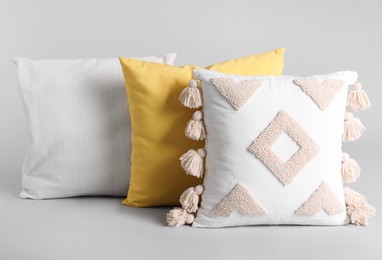 Different stylish soft pillows on grey background Photo of Different stylish soft pillows on grey background