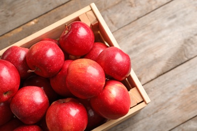 Wooden crate with fresh red apples on table Photo of Wooden crate with fresh red apples on table