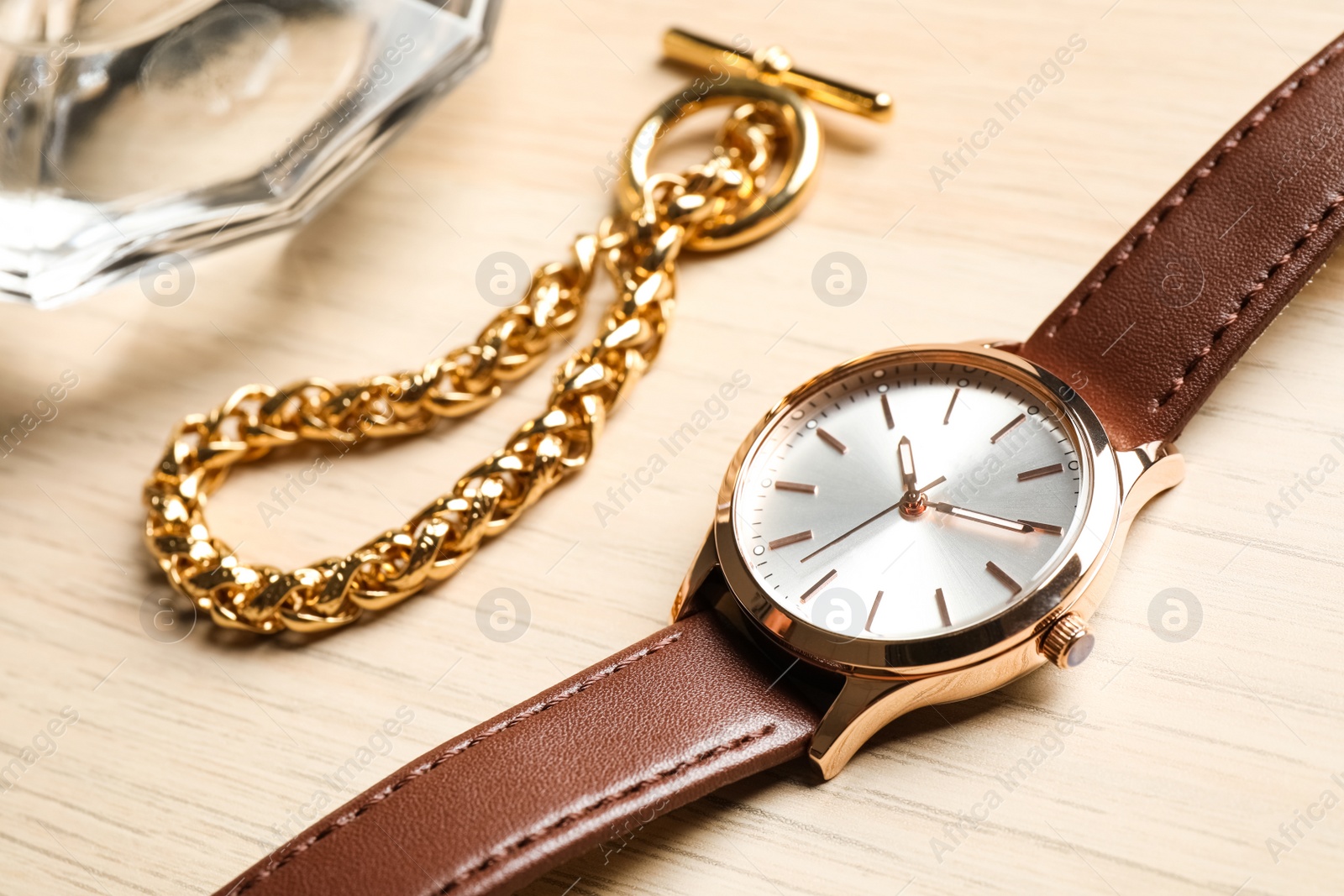 Luxury wrist watch and gold bracelet on wooden background, closeup Photo of Luxury wrist watch and gold bracelet on wooden background, closeup