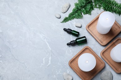 Burning candles, stones and essential oil on grey marble table, flat lay. Space for text Photo of Burning candles, stones and essential oil on grey marble table, flat lay. Space for text
