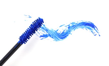 Applicator and blue mascara smear on white background, top view Photo of Applicator and blue mascara smear on white background, top view