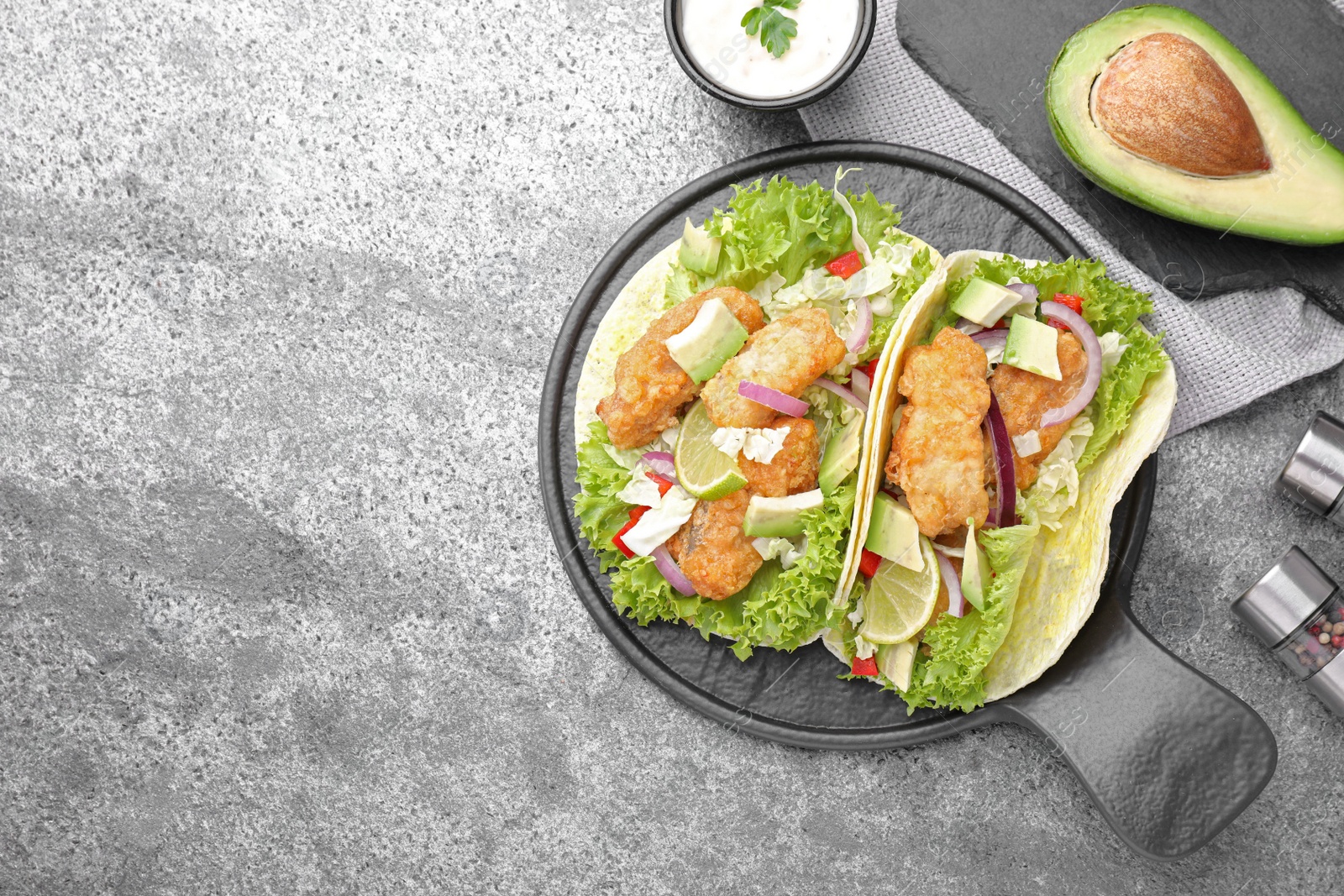 Delicious fish tacos served on grey table, flat lay with space for text Photo of Delicious fish tacos served on grey table, flat lay with space for text