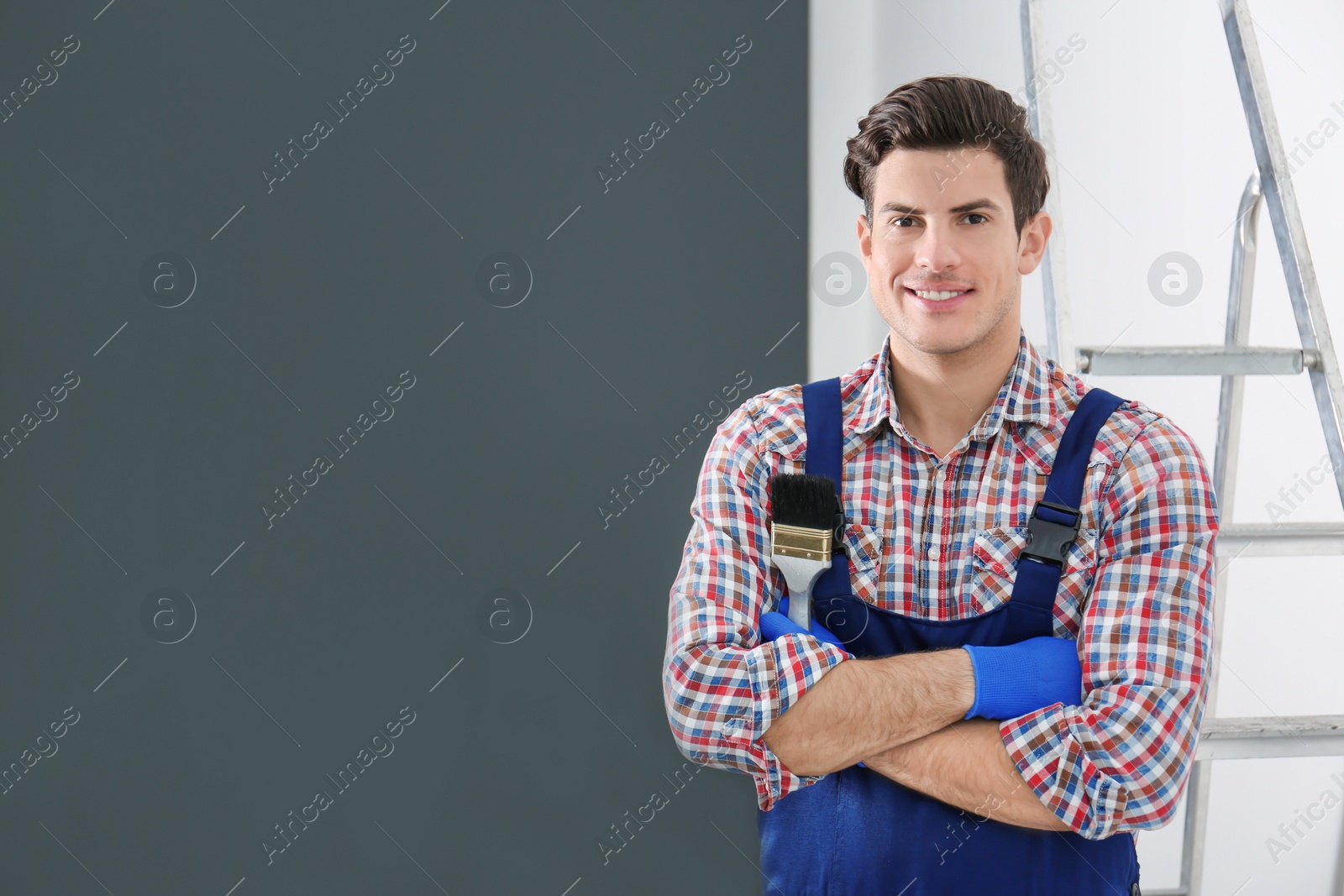 Portrait of male decorator with brush indoors Photo of Portrait of male decorator with brush indoors