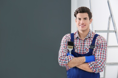 Portrait of male decorator with brush indoors Photo of Portrait of male decorator with brush indoors