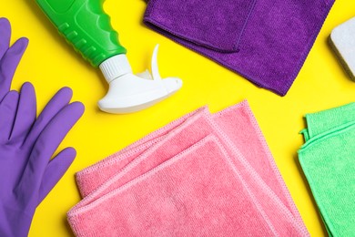 Microfiber cloths and cleaning supplies on yellow background, flat lay Photo of Microfiber cloths and cleaning supplies on yellow background, flat lay