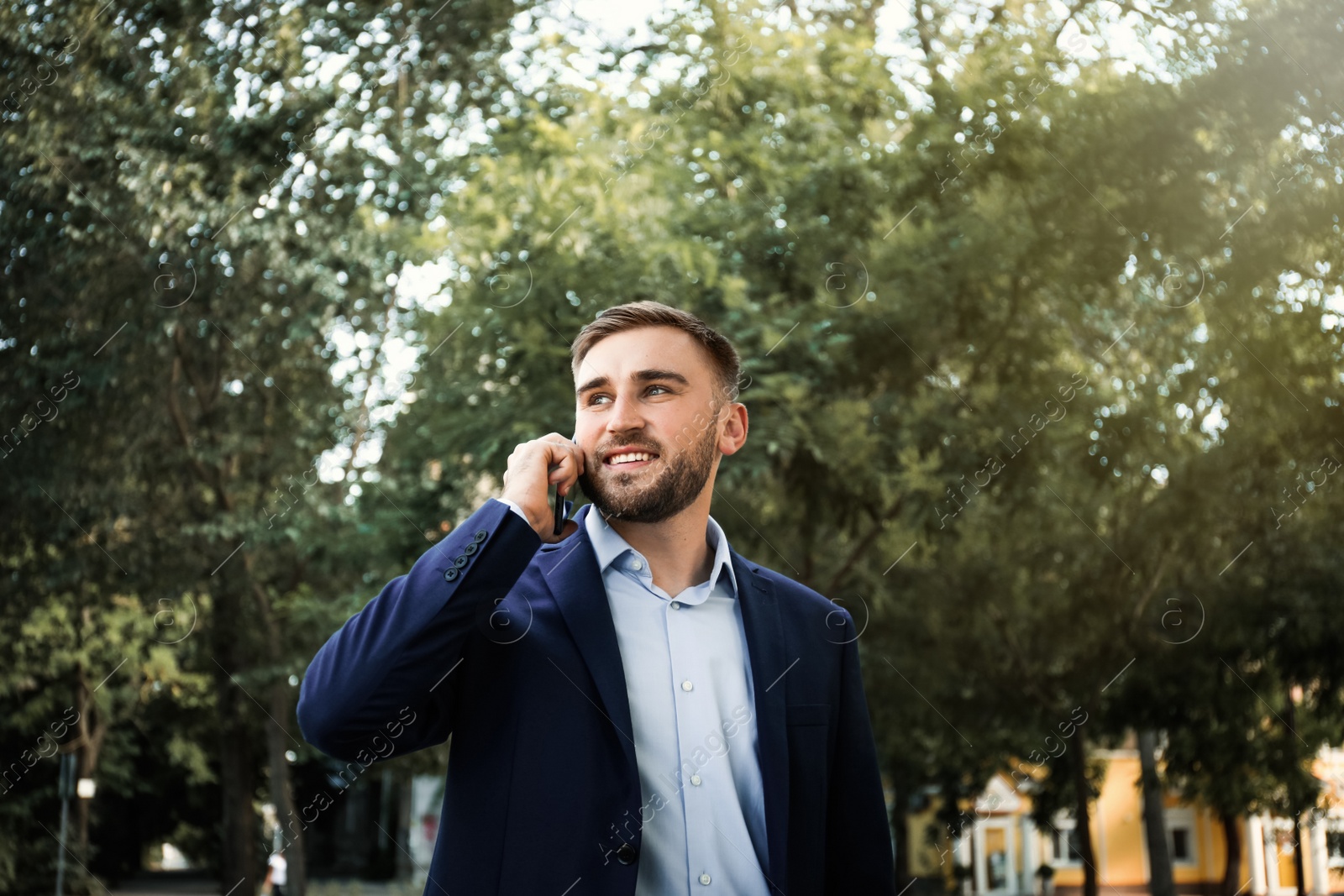 Young man talking on smartphone in park Photo of Young man talking on smartphone in park
